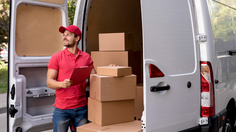 A delivery man is packing product boxes